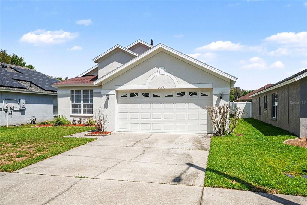 30631 Nickerson Loop Wesley Chapel, FL 33543 - Photo 5 of 33 a front view of a house with garden