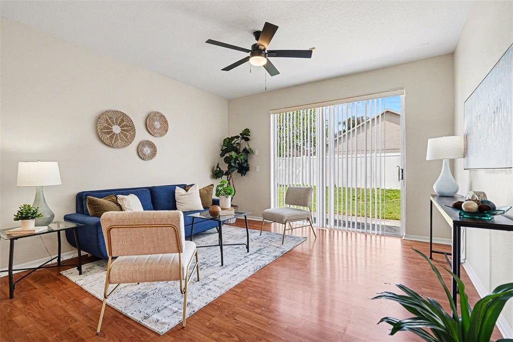 30631 Nickerson Loop Wesley Chapel, FL 33543 - Photo 9 of 33 a living room with furniture and a large window with wooden floor