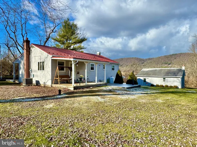 a view of a house with a swimming pool and a yard