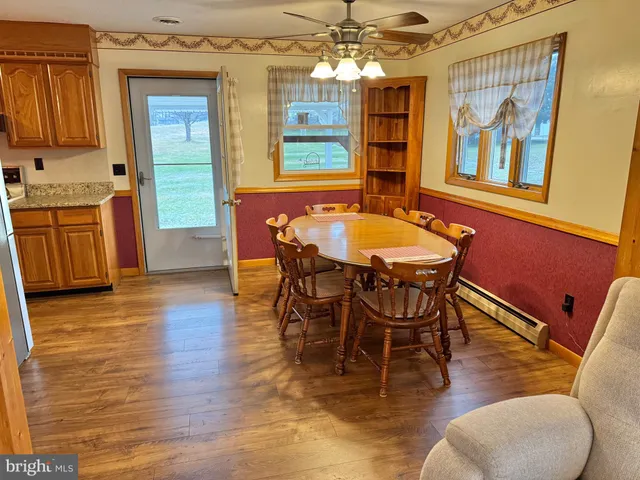 a dining room with wooden floor and chandelier