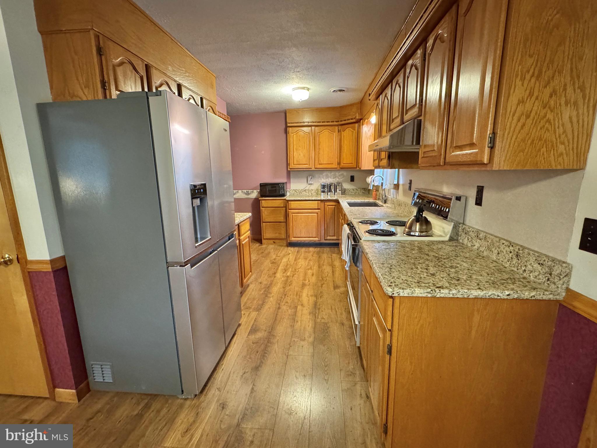 115 Upper Gyp Road Bellefonte, PA 16823 - Photo 7 of 27 a kitchen with sink a refrigerator and wooden floor