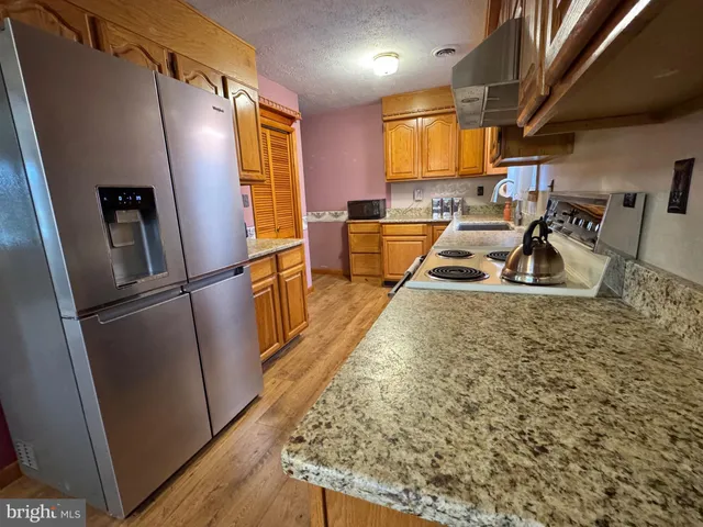a kitchen with granite countertop a refrigerator and a sink