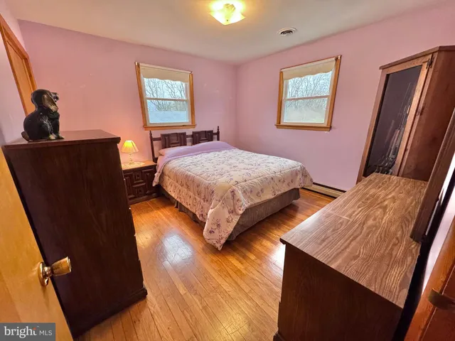 a bedroom with bed and wooden floor