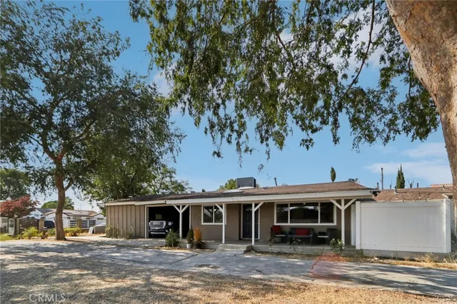 a view of a white house with a large tree