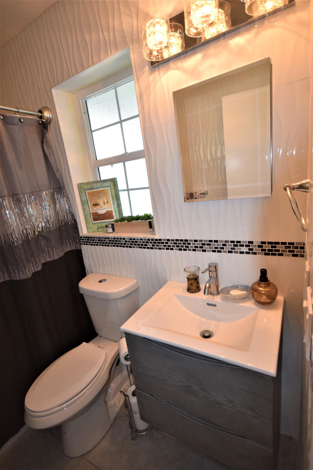 2770 Northeast 25th Terrace Boca Raton, FL 33431 - Photo 15 of 34 a bathroom with a sink mirror and toilet