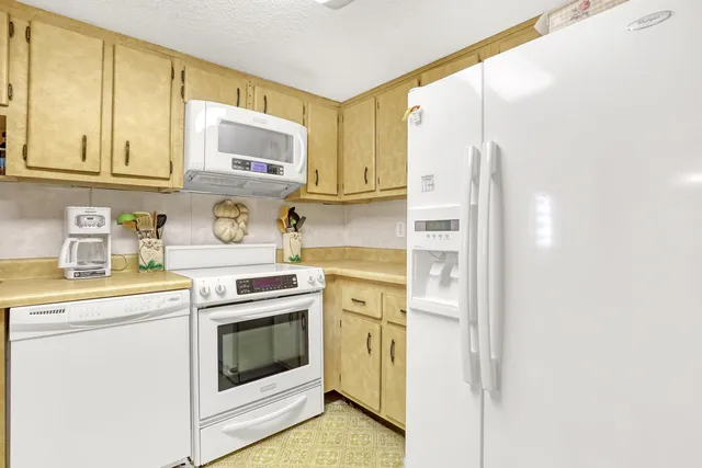 a kitchen with stainless steel appliances white cabinets and a refrigerator