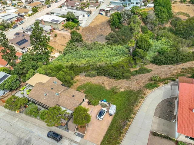 an aerial view of a house with a yard and lake view in back