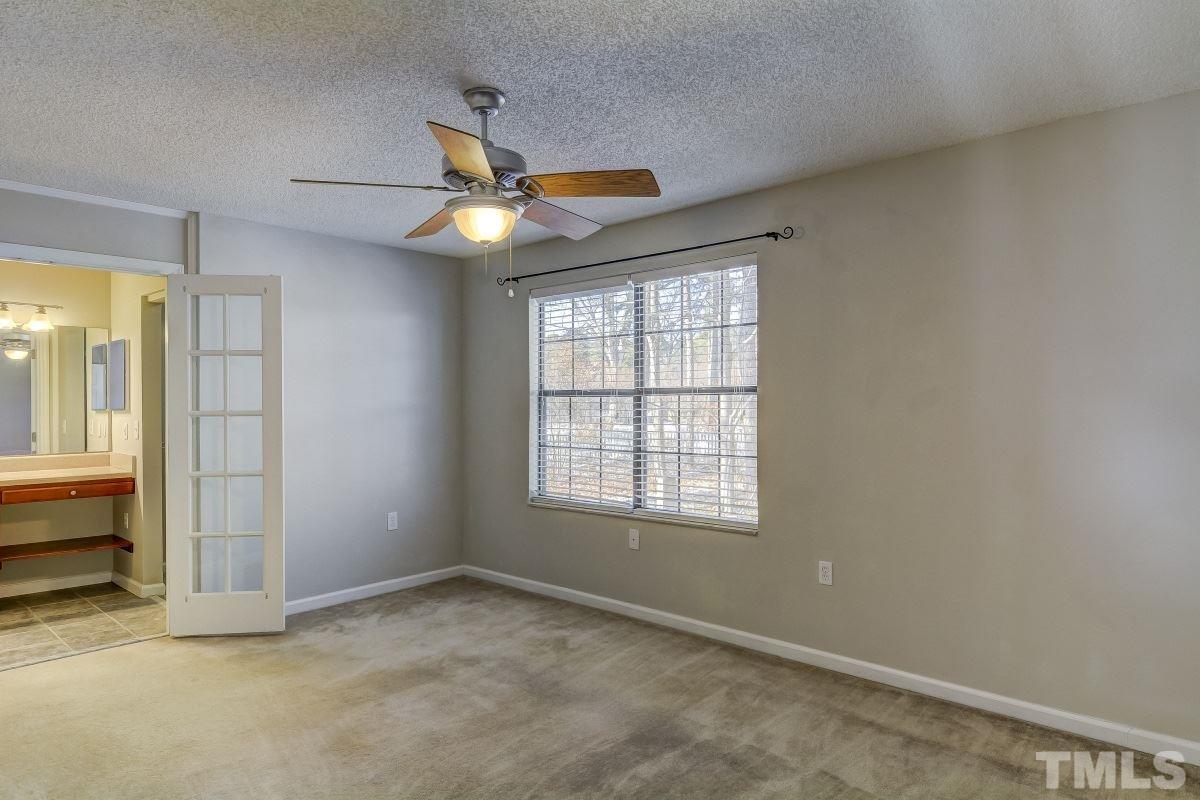 7607 Falcon Rest Circle, Unit 7607 Raleigh, NC 27615 - Photo 8 of 12 an empty room with chandelier fan and windows