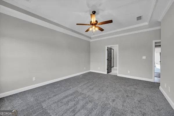an empty room with closet and a chandelier fan