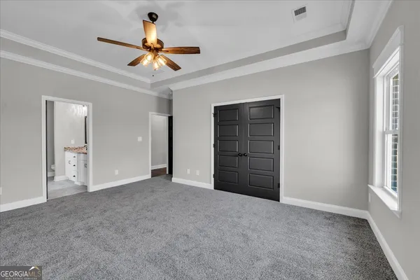 a view of an empty room with a ceiling fan and window