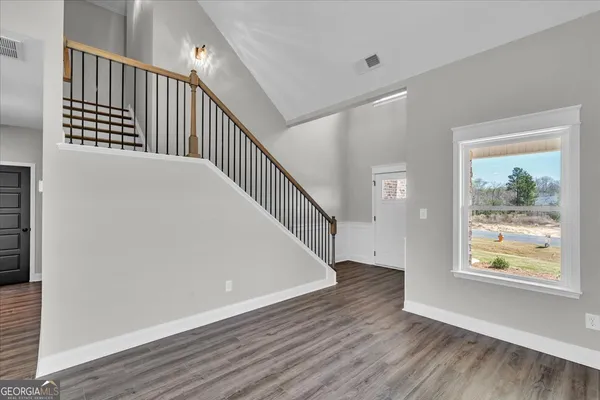 a view of a hallway with wooden floor and windows