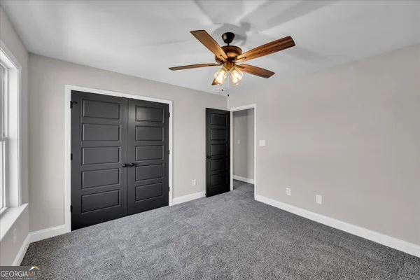 a view of a big room with closet and ceiling fan