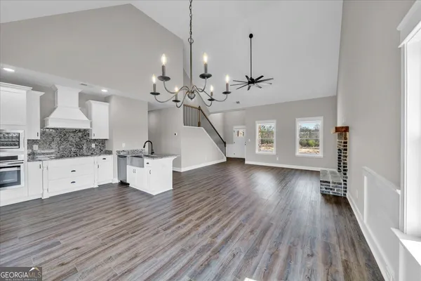 a open kitchen with white cabinets and wooden floor