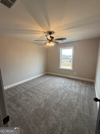 an empty room with windows and fan