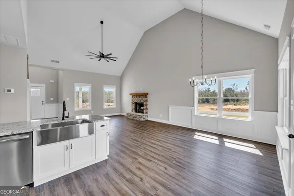 a large kitchen with cabinets wooden floor and stainless steel appliances
