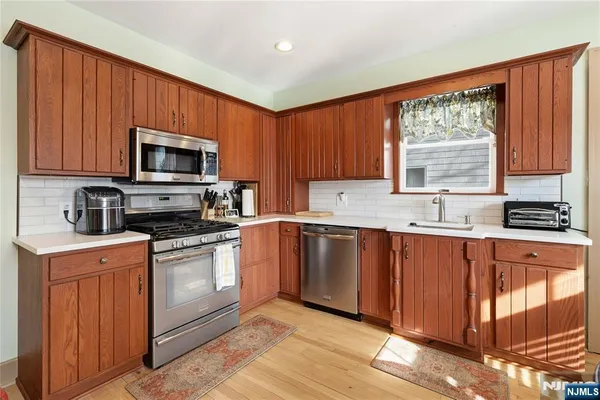 a kitchen with stainless steel appliances granite countertop a stove a sink dishwasher and a microwave oven with cabinets