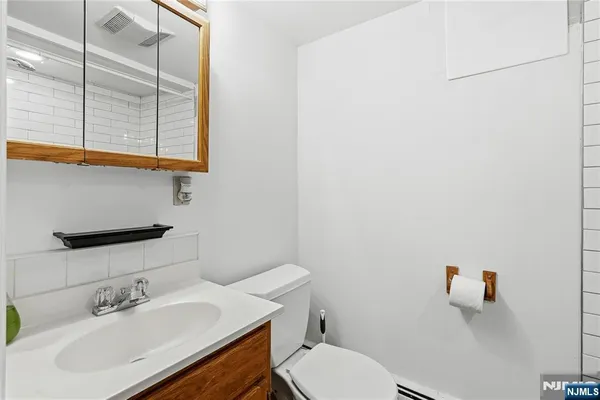 a bathroom with a sink vanity mirror and toilet