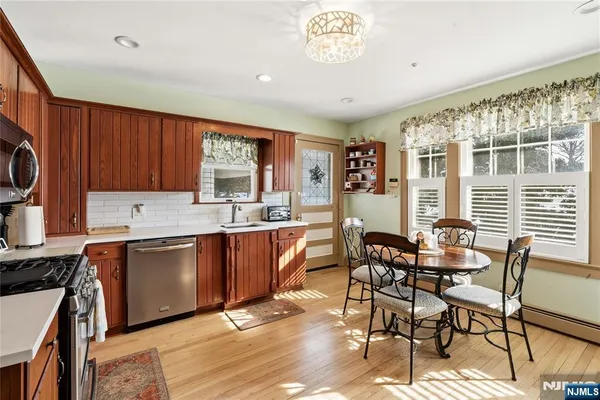 a open kitchen with stainless steel appliances granite countertop a table chairs sink and cabinets