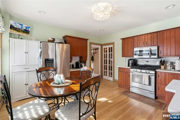 a kitchen with stainless steel appliances a dining table and chairs