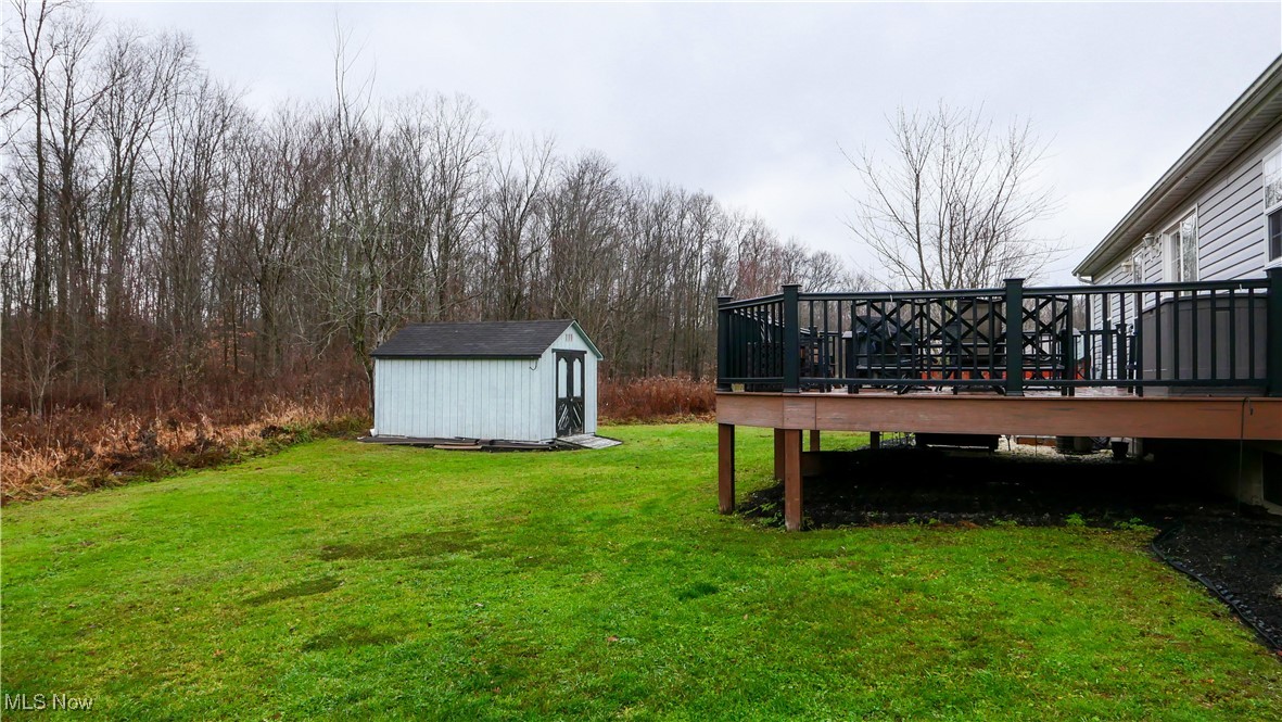 17296 Old State Road Middlefield, OH 44062 - Photo 34 of 44 View of yard with a wooden deck and a storage unit