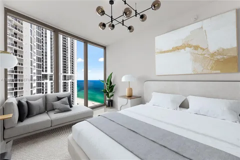 a bedroom with a large bed couch and a large window