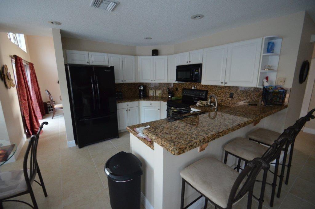 6563 Constance Street, Unit 6563 Lake Worth, FL 33467 - Photo 6 of 16 a kitchen with stainless steel appliances granite countertop a sink refrigerator and microwave