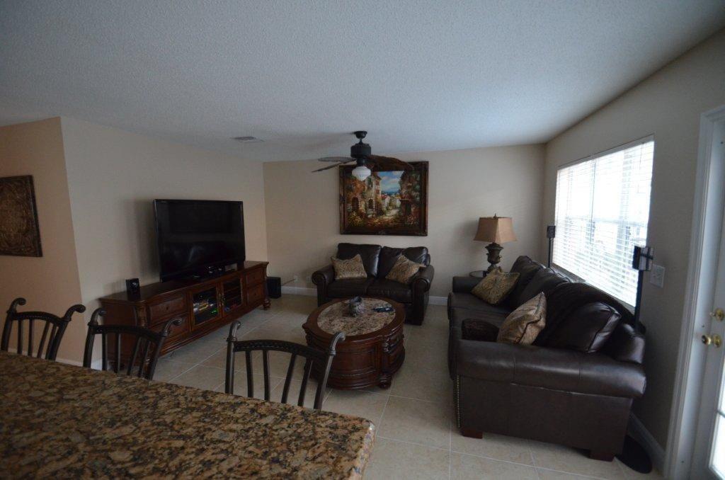 6563 Constance Street, Unit 6563 Lake Worth, FL 33467 - Photo 8 of 16 a living room with furniture and a flat screen tv