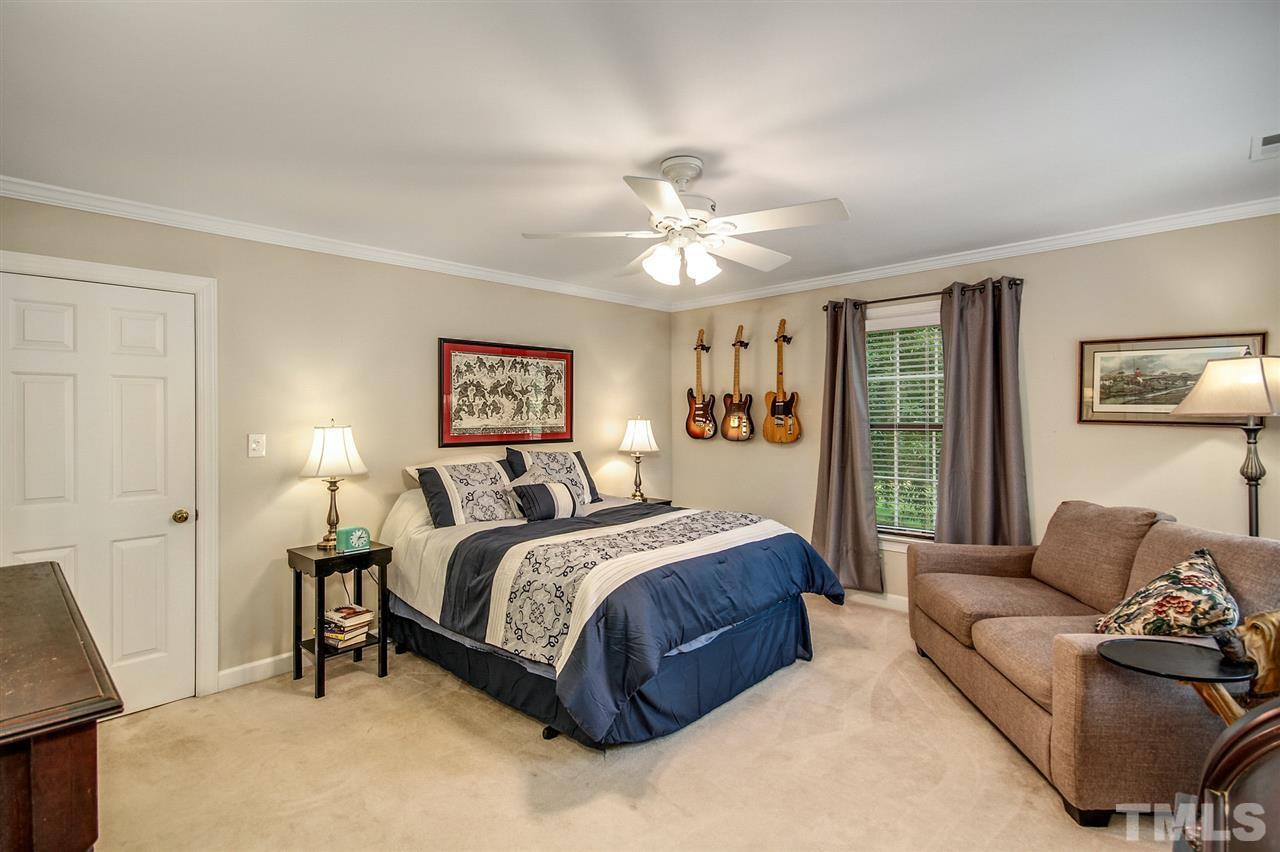 566 Weathergreen Drive Raleigh, NC 27615 - Photo 16 of 28 a spacious bedroom with a bed a couch and a dresser next to a window