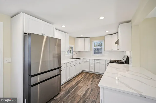 a kitchen with white cabinets and stainless steel appliances