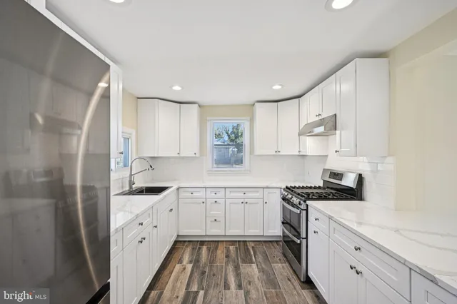 a kitchen with granite countertop a sink stainless steel appliances and cabinets