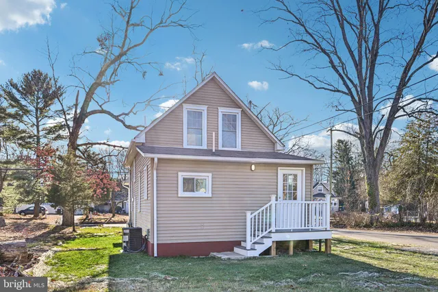 a front view of a house with a yard tree and wooden fence