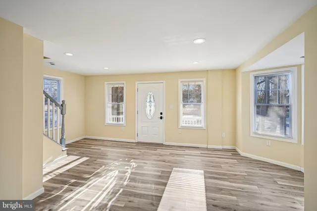 a view of an empty room with a window and bathroom