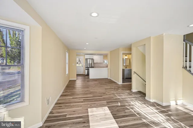 a view of a hallway with wooden floor and windows
