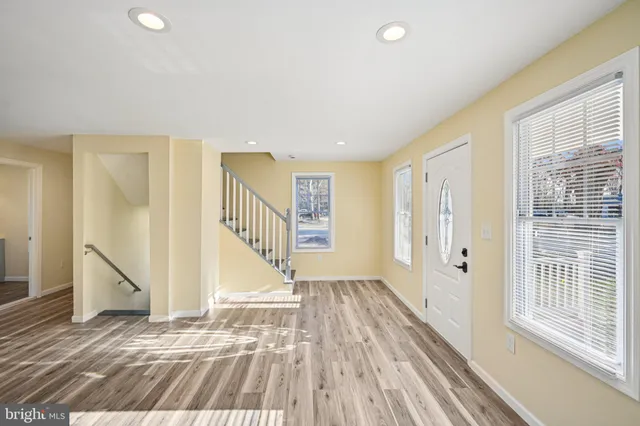 a view of a hallway with wooden floor and staircase