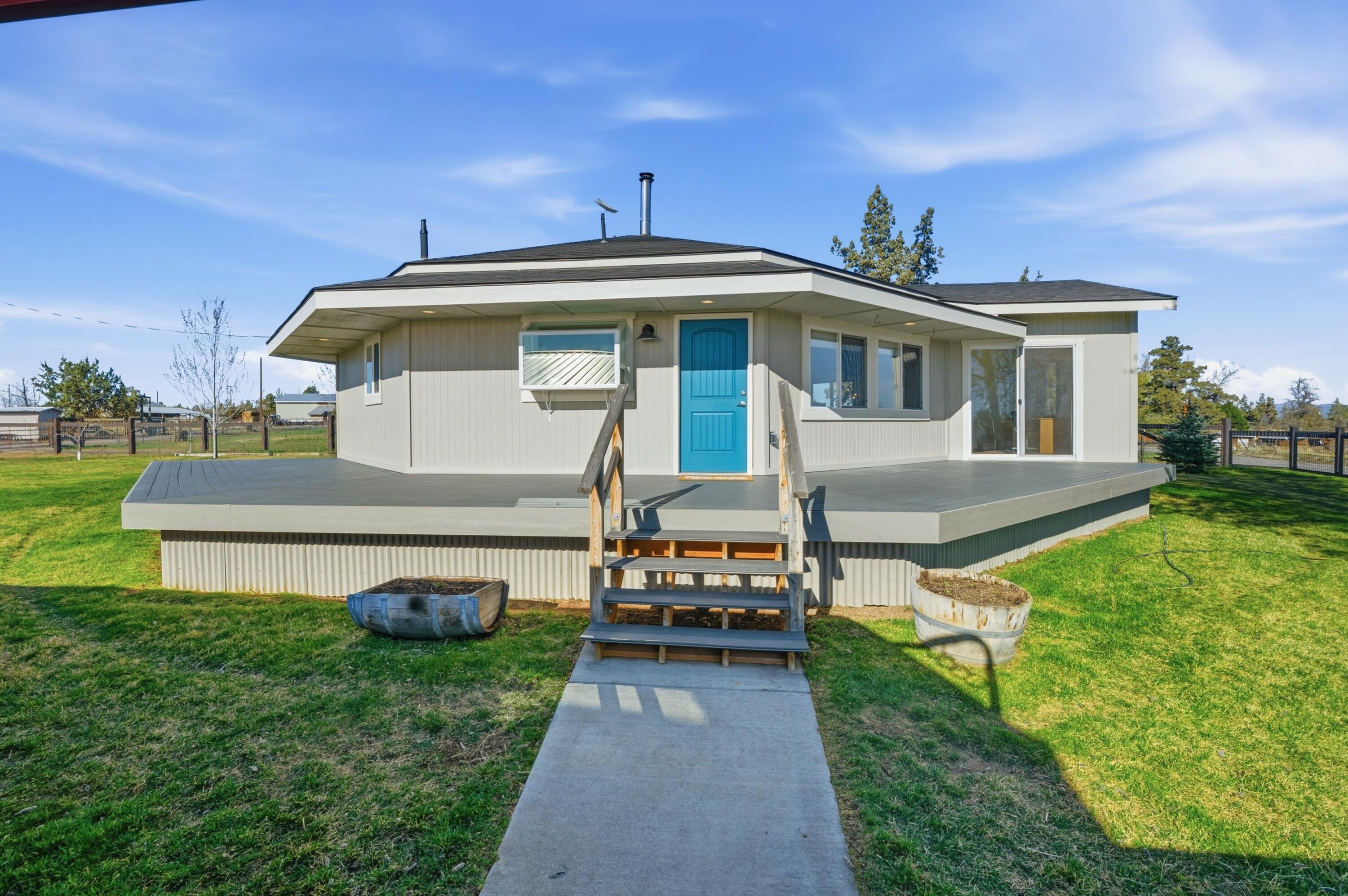 4074 Southwest Reif Road Powell Butte, OR 97753 - Photo 2 of 59 a front view of a house with garden