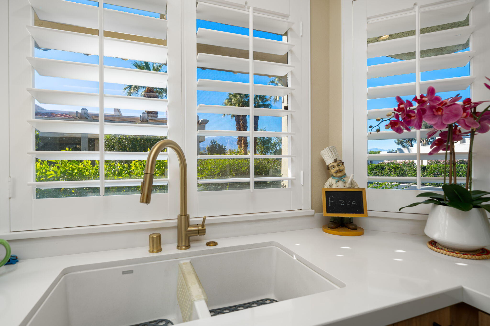 255 Vía Rengo Palm Desert, CA 92260 - Photo 17 of 32 a kitchen with a sink and a large window