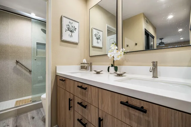 a bathroom with a toilet sink vanity granite and mirror