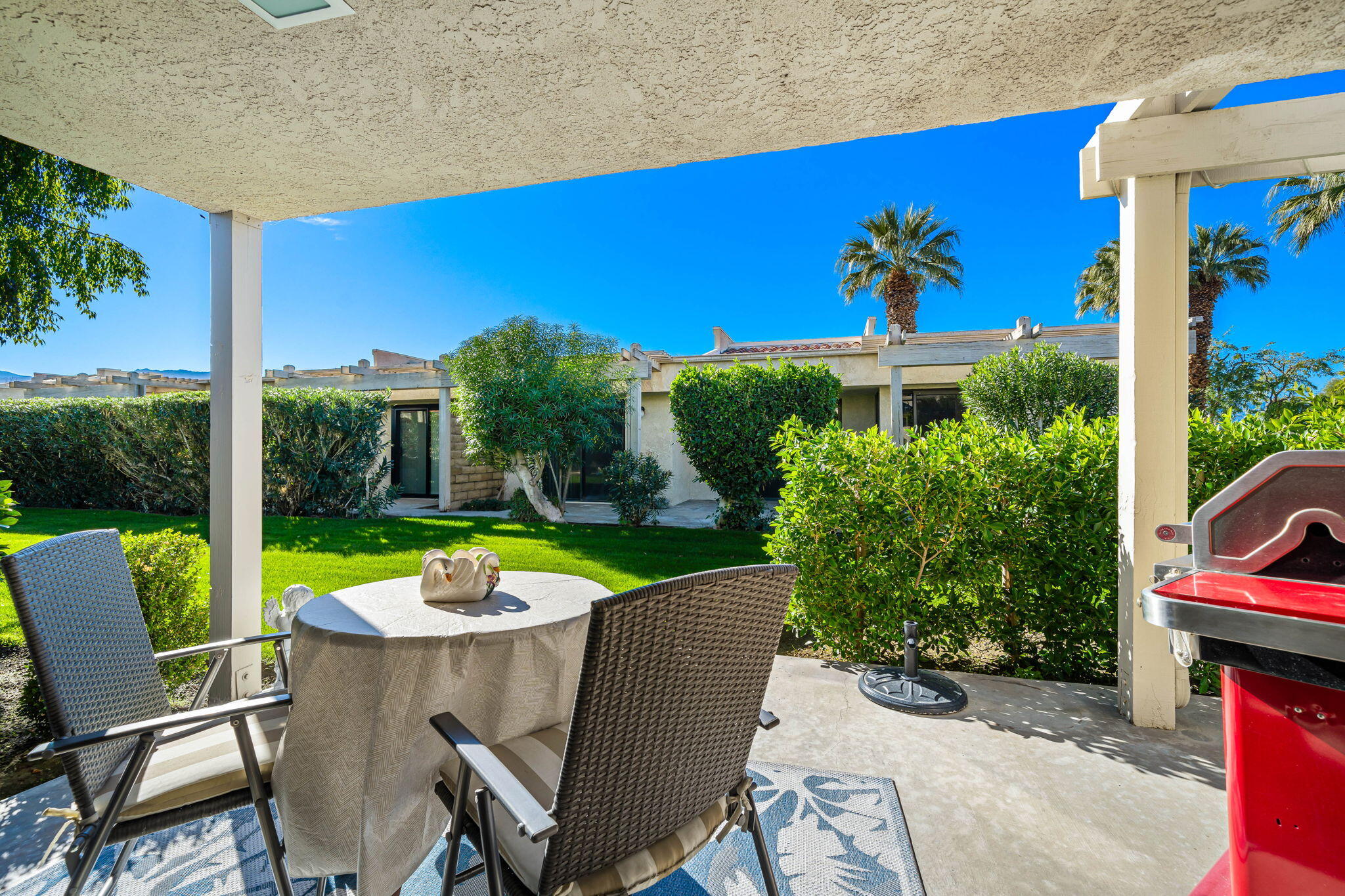 255 Vía Rengo Palm Desert, CA 92260 - Photo 25 of 32 a view of a chairs and table in patio with a fire pit