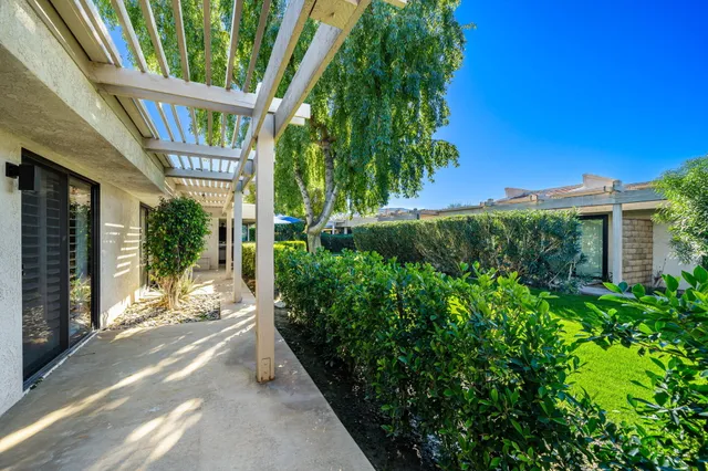 a view of a patio with table and chairs potted plants with floor to ceiling window