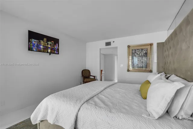 a bedroom with a bed and a painting on the wall