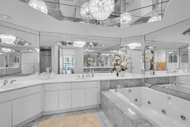 a large bathroom with a large tub sink vanity granite and shower