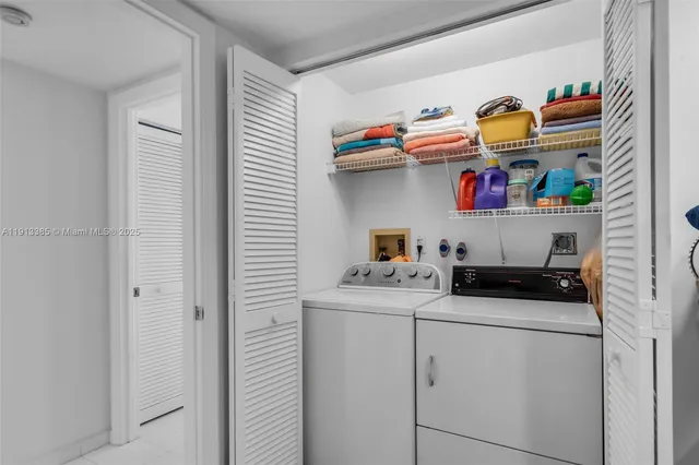 a utility room with fridge and wooden floor
