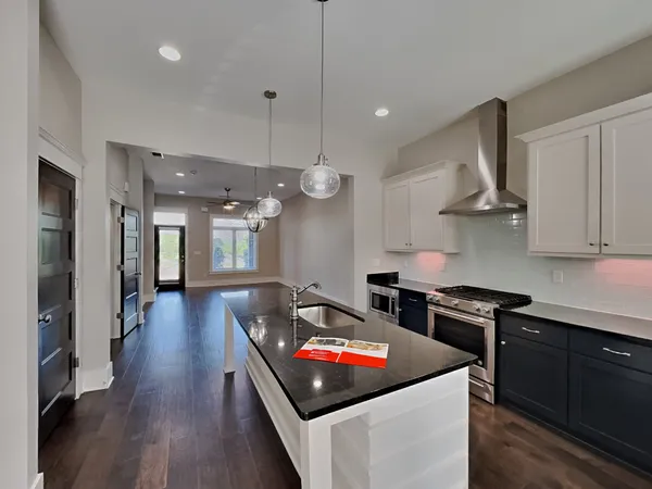 a kitchen with stainless steel appliances a stove a sink a refrigerator and cabinets