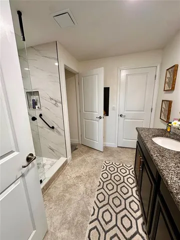 a spacious bathroom with a granite countertop sink a toilet and a mirror