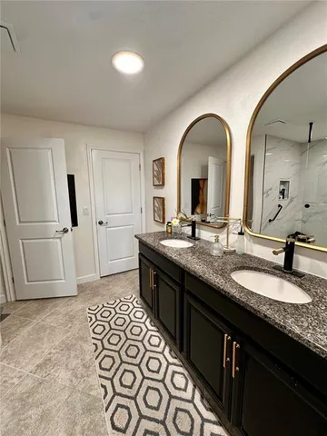 a bathroom with a double vanity sink and a mirror