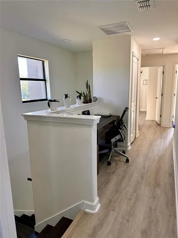 a view of a hallway with wooden floor and a living room