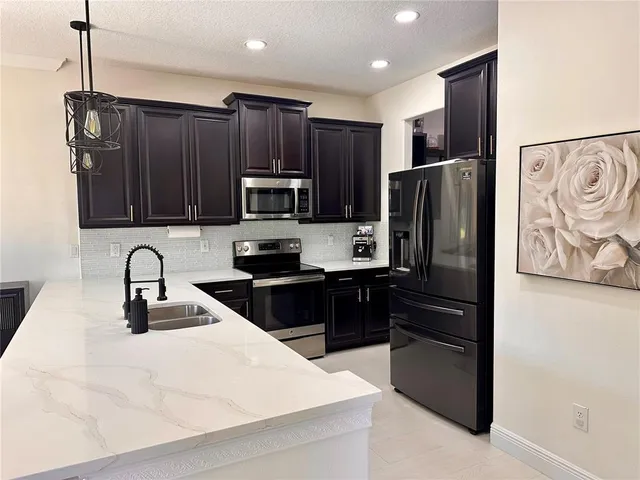 a kitchen with granite countertop a refrigerator and a sink