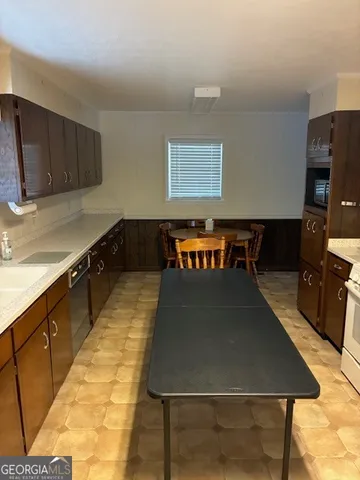 a large kitchen with kitchen island a sink table and chairs