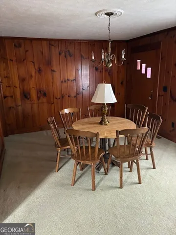 a dining room with furniture and chandelier painted walls