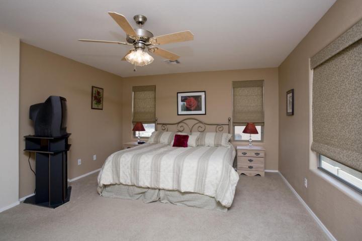 3815 East Chickadee Road Gilbert, AZ 85297 - Photo 4 of 9 a bedroom with a bed and a chandelier